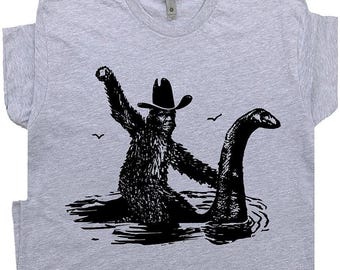 Funny Bigfoot T Shirt Cool Loch Ness Monster Shirt Cool Big Foot Tshirt for Men Women Boys Riding Nessie Cryptid Shirt Sasquatch Graphic Tee