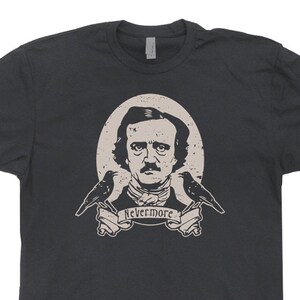 May include: A dark grey t-shirt featuring a vintage-style illustration of Edgar Allan Poe, two ravens, and the text "Nevermore".
