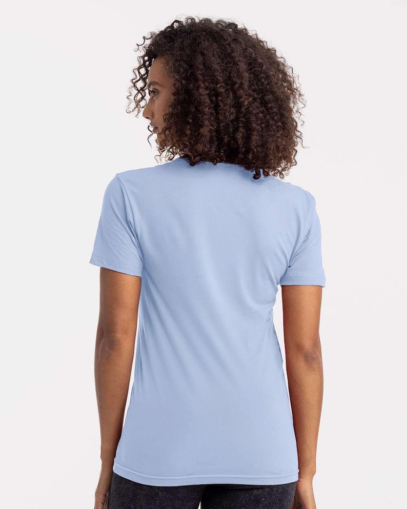 Puede incluir: Una camiseta azul claro de manga corta. La camiseta est&aacute; hecha de un material suave y tiene cuello redondo. La modelo lleva la camiseta, de espaldas a la c&aacute;mara. La camiseta es de color liso.