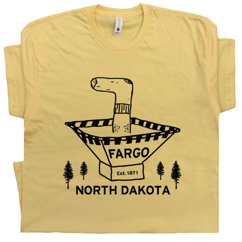 May include: A yellow t-shirt with a black illustration of a sock in a traffic cone. The text on the t-shirt reads 'Fargo Est. 1871 North Dakota'.