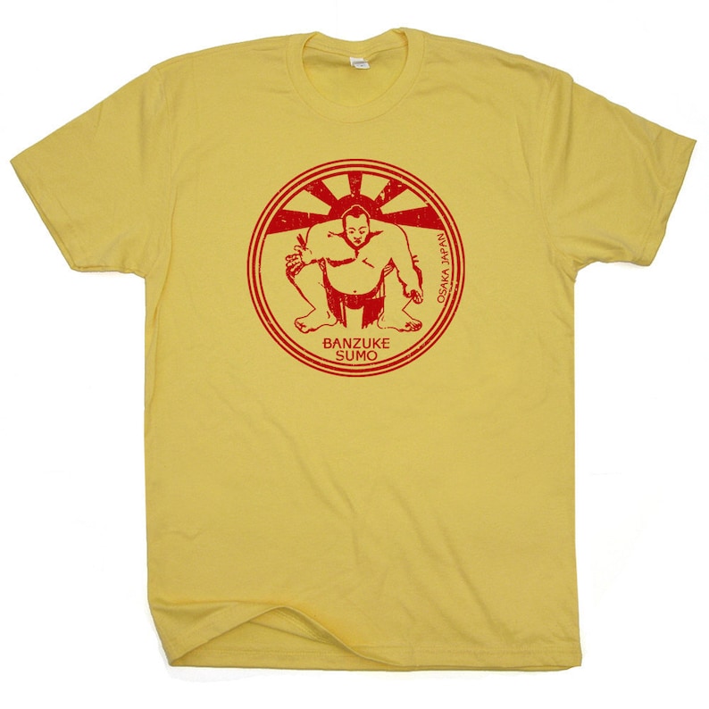 May include: Yellow t-shirt with a red circle graphic of a sumo wrestler in a fighting stance. The circle has the text "BANZUKE SUMO" and "OSAKA YASUI" in red.