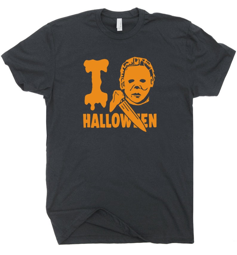 May include: A black t-shirt with an orange graphic of a masked figure holding a knife and the text "I  HALLOWEEN".