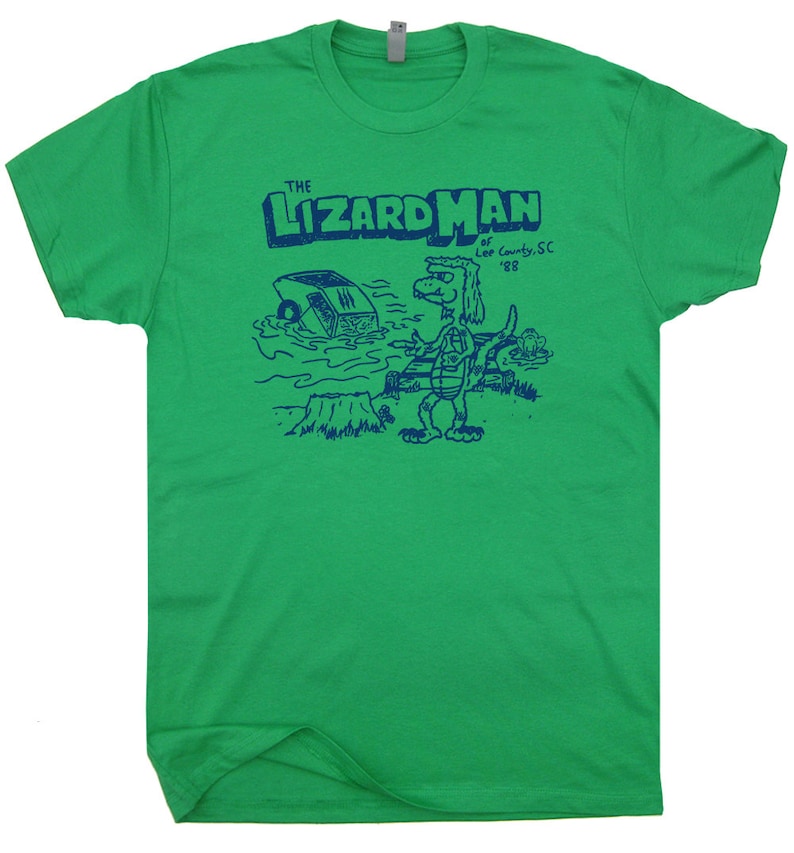 May include: Green t-shirt with a blue graphic of a cartoon lizard with the text "The Lizard Man of Lee County, SC '88"