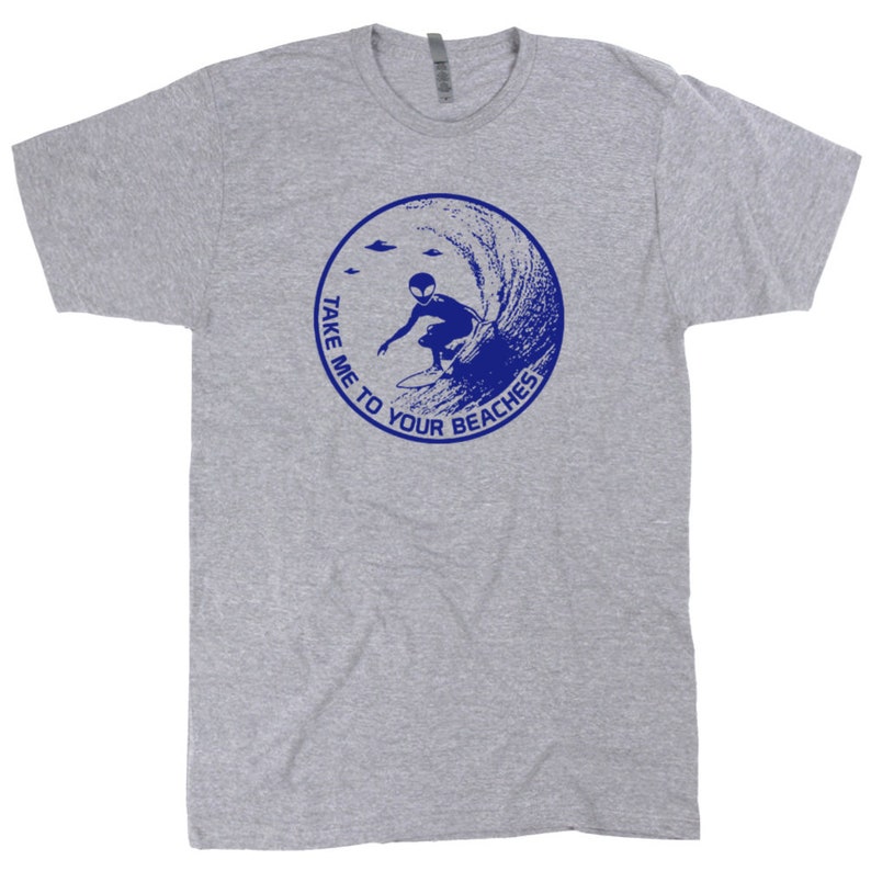 May include: A gray t-shirt with a blue graphic of an alien surfing a wave. The graphic is in a circle with the text "Take me to your beaches" around it.