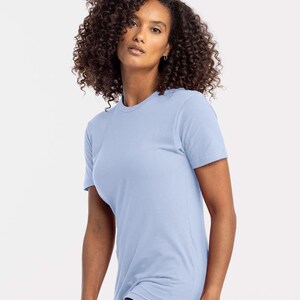 Puede incluir: Una camiseta azul claro con cuello redondo. La camiseta de manga corta est&aacute; hecha de un material suave. La modelo lleva vaqueros negros. La camiseta es de color liso y tiene un dise&ntilde;o cl&aacute;sico y sencillo.