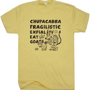 May include: Yellow t-shirt with a black graphic of a cartoon monster and goat, with the words "CHUPACABRA FRAGILISTIC EXPIAL EAT GOATS". The shirt is made of a soft material.