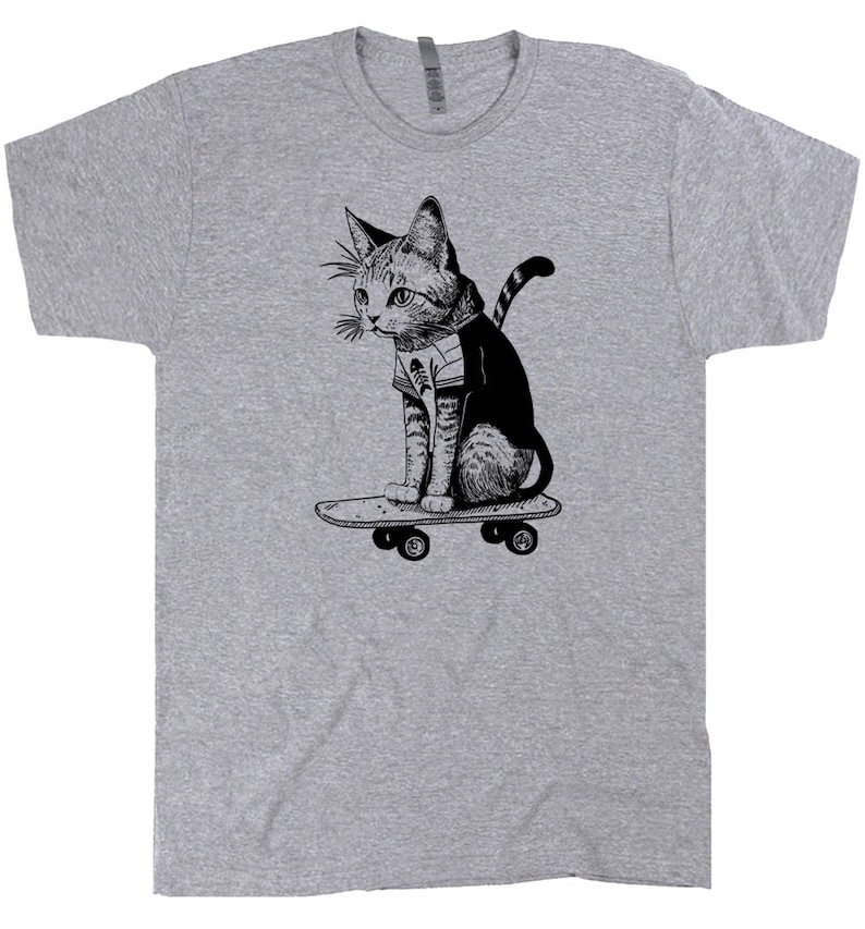 May include: A gray t-shirt with a black and white illustration of a cat skateboarding. The cat is wearing a striped shirt and has a bandana around its neck.