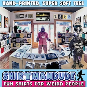 May include: A shop called "Shirtmandu" with the tagline "Fun Shirts for Weird People" is filled with stacks of colorful t-shirts. The shop is decorated with a variety of quirky artwork and a large, furry creature wearing a pink shirt stands in the doorway.