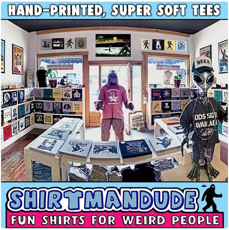 May include: A shop called "Shirtmandu" with the tagline "Fun Shirts for Weird People" sells hand-printed, super soft t-shirts. The shop is decorated with a variety of t-shirts, posters, and other items. There are two figures in the shop, one dressed as a Bigfoot and the other as an alien.