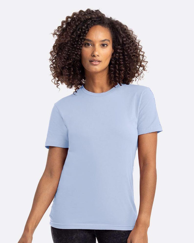 Puede incluir: Una camiseta azul claro con cuello redondo. La camiseta de manga corta est&aacute; hecha de un material suave. La modelo lleva la camiseta. La camiseta es de color liso y tiene un dise&ntilde;o cl&aacute;sico.