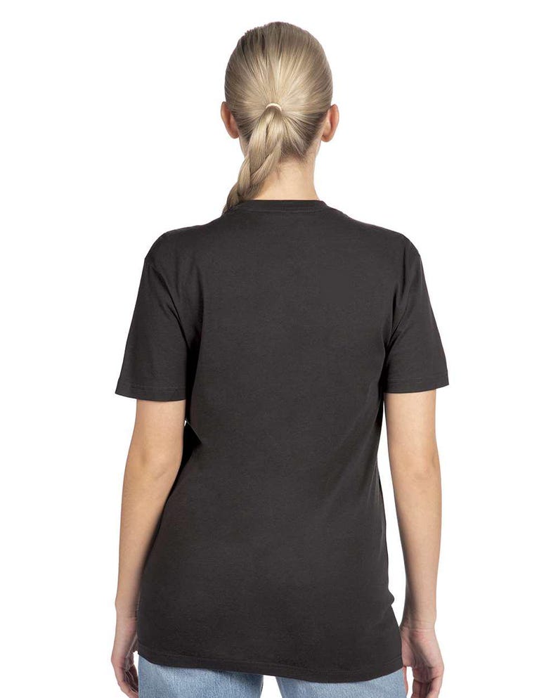 May include: A black short-sleeve t-shirt. The back of the shirt is visible, worn by a person with blonde hair pulled back in a ponytail. The shirt is a solid color and appears to be made of a soft material.