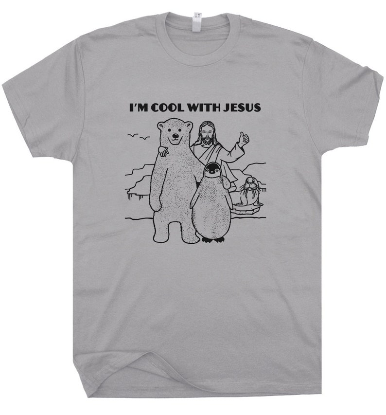 May include: A gray t-shirt with a black graphic of Jesus, a polar bear, a penguin, and a seal. The text "I'm Cool With Jesus" is printed on the shirt.