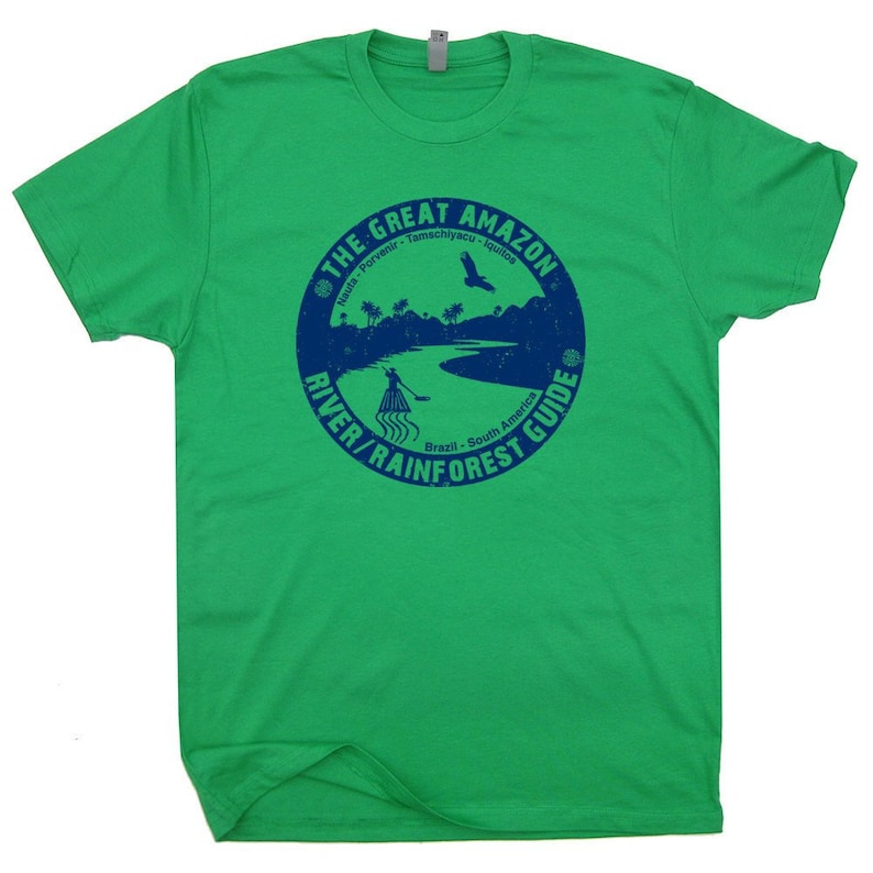 Pu&ograve; includere: Maglietta verde con un grafico circolare blu che dice "The Great Amazon River/Rainforest Guide" con testo che dice "Nauta - Porvenir - Tamachivaculau - Iquitos" e "Brasile - Sud America".