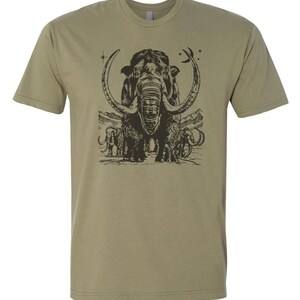 May include: A khaki green t-shirt with a black and white illustration of a woolly mammoth with its tusks curved into a crescent shape. The mammoth is surrounded by smaller mammoths and stars.