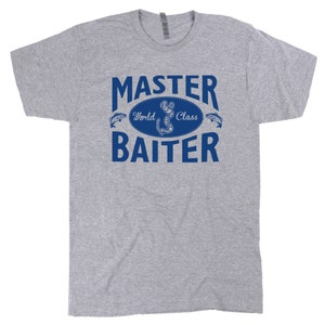 Puede incluir: Una camiseta gris con un gr&aacute;fico azul que dice "Master World Class Baiter" con un dise&ntilde;o de pez y anzuelo.