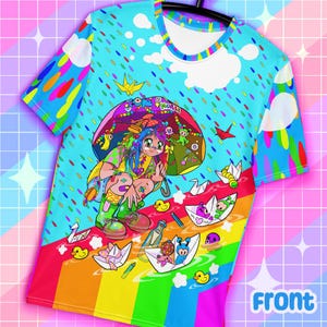 May include: A colorful t-shirt featuring a vibrant anime-style illustration. The design includes a girl under an umbrella, paper boats, ducks, and a rainbow. The sleeves and collar have rainbow accents, and the background is a light blue with rain.