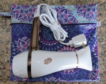 May include: A white and rose gold hair dryer with a white cord and plug, resting on a patterned pouch. The pouch features a purple, blue, and pink mandala design. The hair dryer has a diamond-cut design on the nozzle.
