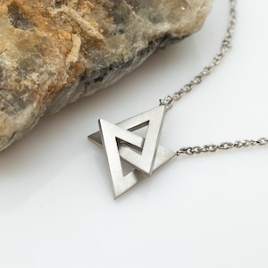 May include: A silver necklace with a pendant featuring two interlocking triangles.