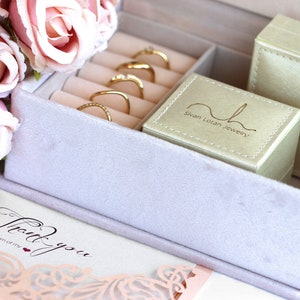 May include: A light purple velvet jewellery box with gold rings inside. The box has a white card that says "Thank you from the bottom of my heart."  The box also has a small green box with the text "Sivan Loian Jewellery" on it.