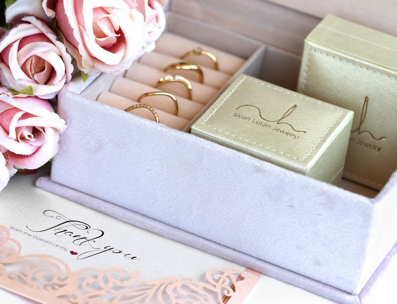 May include: A light purple velvet jewellery box with gold rings inside. The box has a white card that says "Thank you from the bottom of my heart."  The box also has a small green box with the text "Sivan Loian Jewellery" on it.