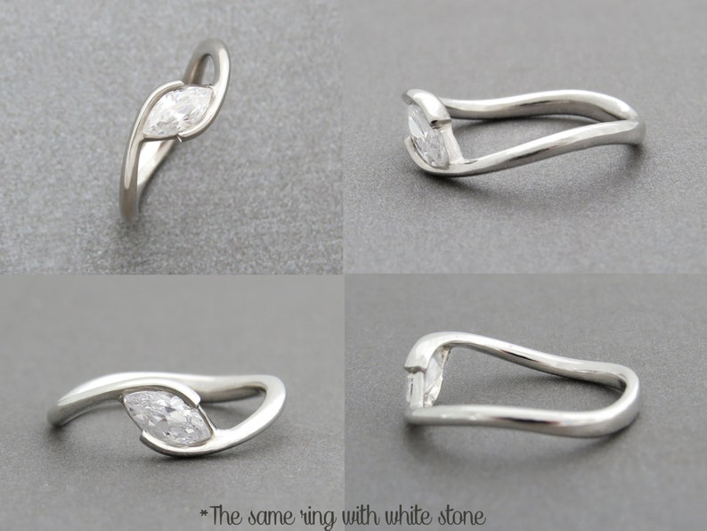 Op de afbeelding: Een zilveren ring met een marquise-vormige diamant gezet in een gebogen band.
