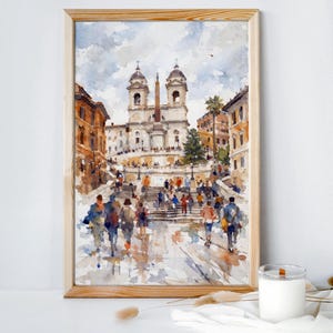 May include: Watercolor painting of the Spanish Steps in Rome, Italy, framed in light wood. The artwork depicts the iconic staircase with people ascending and descending, and buildings in shades of orange and brown.