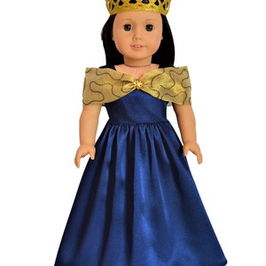 May include: A doll wearing a blue satin dress with a gold and brown trim. The doll is wearing a gold crown.