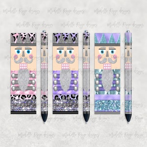 Puede incluir: Tres bolígrafos y tres estuches con diseño de cascanueces. Los bolígrafos y estuches presentan una cara de color canela claro con ojos azules, bigote plateado y barba plateada. Los estuches y bolígrafos tienen detalles en rosa, morado y azul.