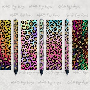 Peut inclure: Ensemble de stylos et de manchons de stylos avec un motif léopard. Les stylos et les manchons présentent un fond dégradé coloré avec des taches noires et des accents de paillettes dorées. Le texte "Michelle Raye designs" est répété.
