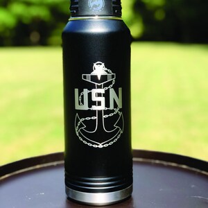 May include: Black stainless steel water bottle with a silver anchor and the text "USN" engraved on the side.