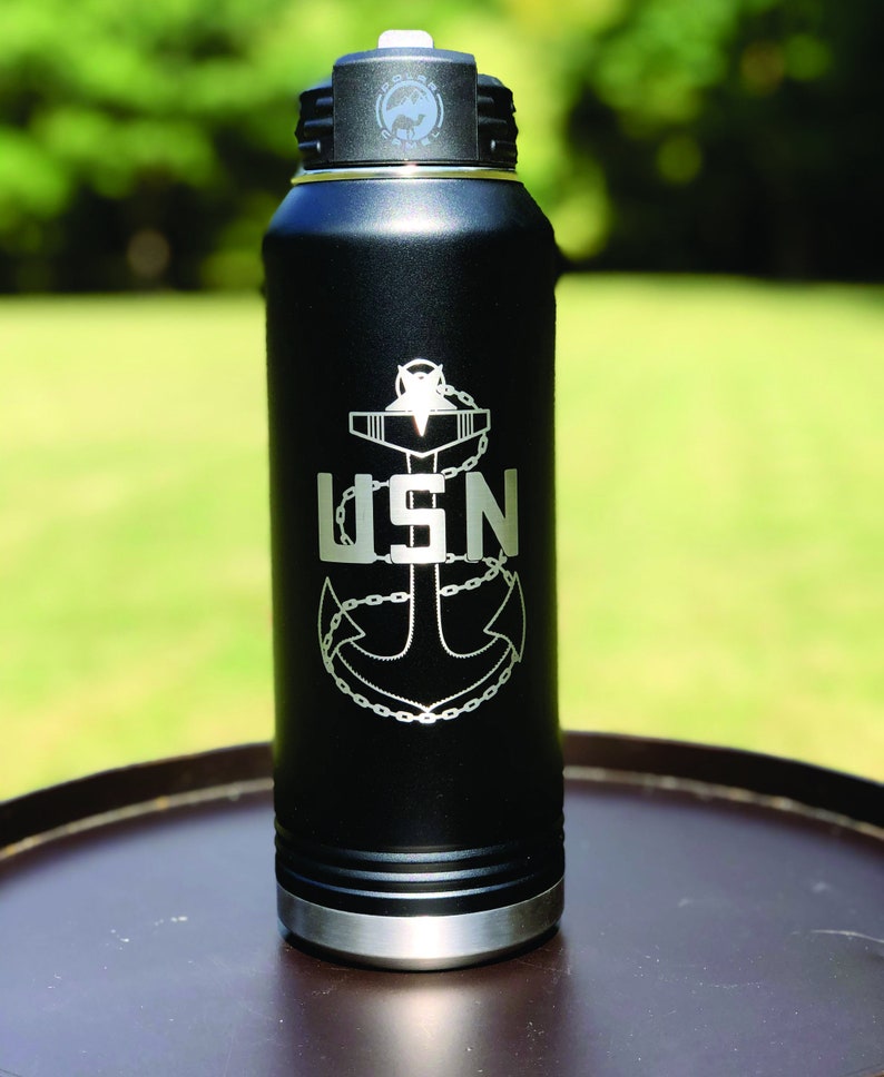 May include: Black stainless steel water bottle with a silver anchor and the text "USN" engraved on the side.