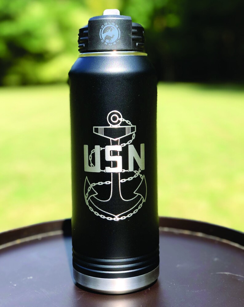 May include: Black stainless steel water bottle with a silver lid and a laser engraved anchor and the letters USN.