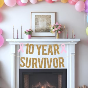 以下が含まれることがあります： 「10 YEAR SURVIVOR」という文字が書かれた金色のグリッターバナーに、ピンクのリボンがアクセントとして付けられています。バナーは、火が燃えている暖炉の上に吊り下げられています。暖炉は、ピンク、イエロー、ブルー、グリーンなど、さまざまな色の風船で飾られています。