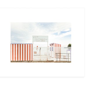 May include: A white gate with a sign that reads "Entrance - Lido di Ostia" in front of a red and white striped wall.