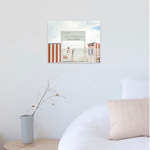May include: A white wooden gate with a red and white striped wall on either side. A sign above the gate reads "Terrazza Bar Marina".