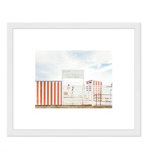 May include: A white gate with a red and white striped fence on either side. The gate has a sign above it that reads "Testaccio Beach Club".