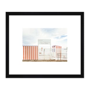 May include: A white gate with a sign that reads "Le Marin Beach Club" in front of a striped red and white fence.
