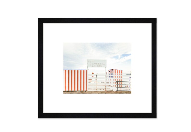 May include: A white gate with a sign that reads "Le Marin Beach Club" in front of a striped red and white fence.