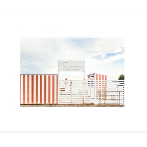 May include: A white wooden gate with a red and white striped fence behind it. The gate has a sign above it that reads "Tiro a Segno La Sirena".