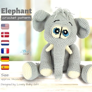 May include: A crocheted gray elephant toy with blue eyes and white tusks. The elephant is sitting on a wooden surface. The toy is approximately 13.4 inches tall.