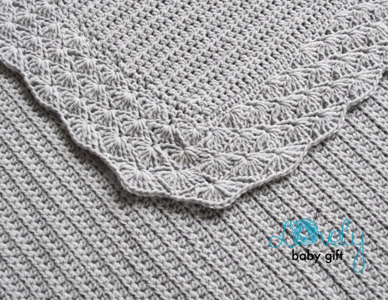 May include: A gray crocheted baby blanket with a scalloped border. The blanket is made with a textured stitch and has a delicate, feminine look.
