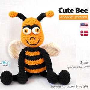 Pode incluir: Um brinquedo de abelha de crochê com listras pretas e laranja, asas brancas e grandes olhos laranja. A abelha está sentada em uma superfície branca. O texto "Cute Bee crochet pattern" está acima da abelha. O texto "Size: approx. 24cm/9.5" está abaixo da abelha. O texto "Designed by Lovely Baby Gift" está na parte inferior da imagem.