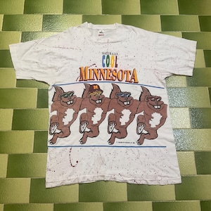May include: White t-shirt with a graphic of four cartoon squirrels wearing sunglasses and a hat, with the text "Naturally Cool Minnesota". The shirt has a speckled design and a blue stripe.