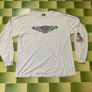 May include: A set of three ceramic mugs with a speckled, matte finish. Each mug features a different color: light blue, cream, and gray. The mugs have a simple, modern design with a rounded shape and a comfortable handle.