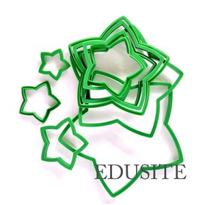 May include: A collection of green star-shaped cookie cutters in various sizes. The cutters are made of plastic and are arranged on a white background. The word "EDUSITE" is printed in black on the bottom right.