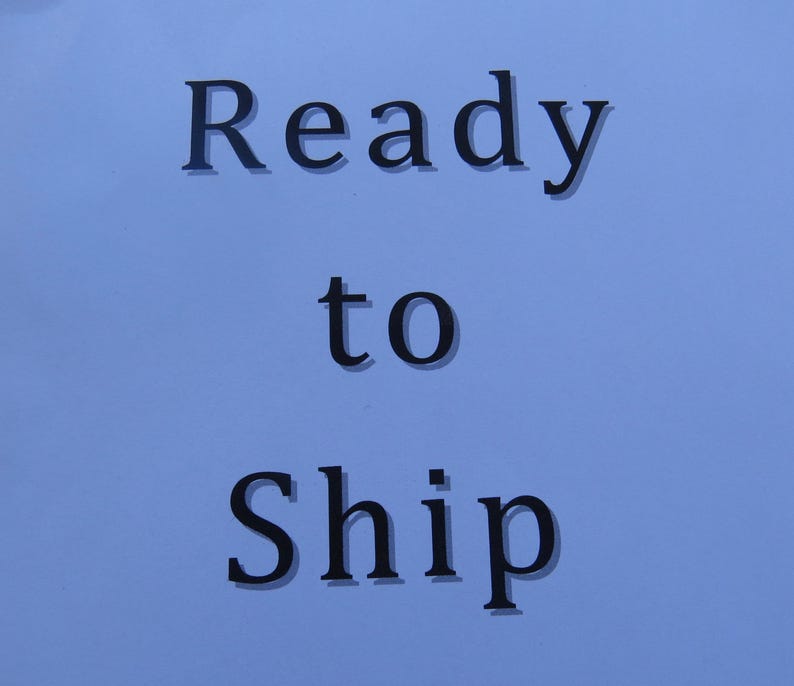 May include: Text on a light blue background reads "Ready to Ship" in a dark, serif font. The words are centered and stacked vertically, with "to" in a smaller font size.
