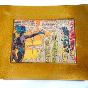 May include: A comic book panel featuring a group of characters trapped in ice. The text reads "NOT EVEN THE GREAT ADAM STRANGE COULD SAVE RANN FROM OUR ATTACK! VICTORY IS OURS!" and "ENCAGED IN SOLID ICE! HOW CAN I POSSIBLY DO ANYTHING TO FREE MYSELF... AND MY FELLOW ICE-PRISONERS?"