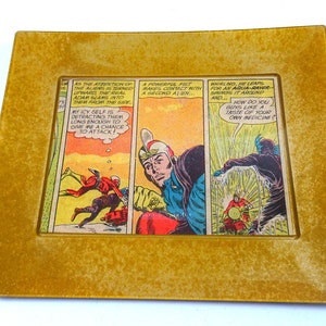 May include: A comic book panel featuring a superhero in a blue and red costume with a helmet. The superhero is fighting two aliens. The text in the panel reads "AS THE ATTENTION OF THE ALIENS IS TERMED UPHARD THE REAL ADAM SLAMS INTO THEM FROM THE SIDE MY ICY SELF IS DETRACTING THEM LONG ENOUGH TO GIVE ME A CHANCE TO ATTACK! A POWERFUL FIST MAKES CONTACT WITH A SECOND ALIEN... WHIRLING, HE LEAPS FOR AN AQUA-RAYER-SWINGS IT AROUND AND... HOW DO YOU GUYS LIKE A TASTE OF YOUR OWN MEDICINE?"