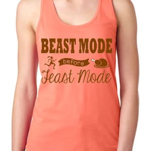 Może przedstawiać: Koronkowy top w kolorze pomarańczowo-koralowym z napisem "Beast Mode before Feast Mode" w brązowych literach. Tekstowi towarzyszy biegnąca postać i grafika indyka.