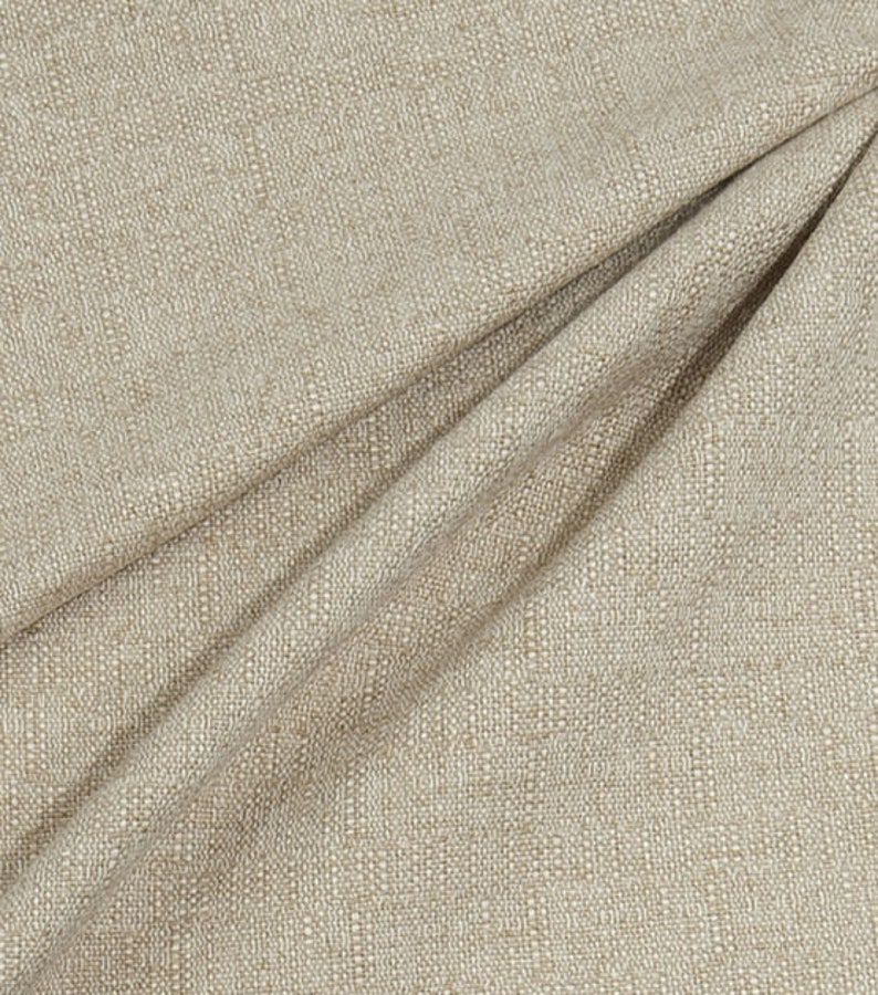 May include: Close-up of a beige fabric with a subtle textured pattern. The fabric has a slightly rough, linen-like feel.